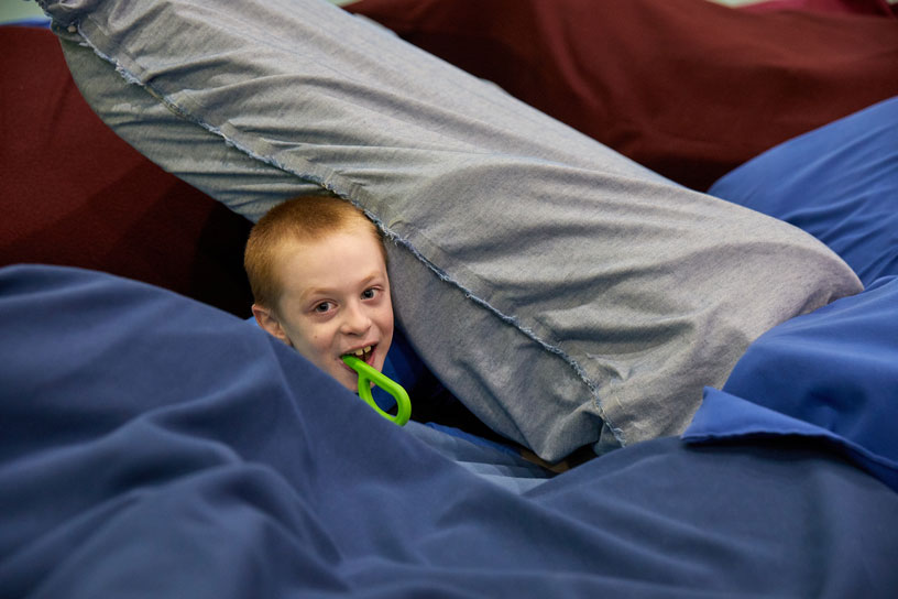 Child plays in crash pad pillows