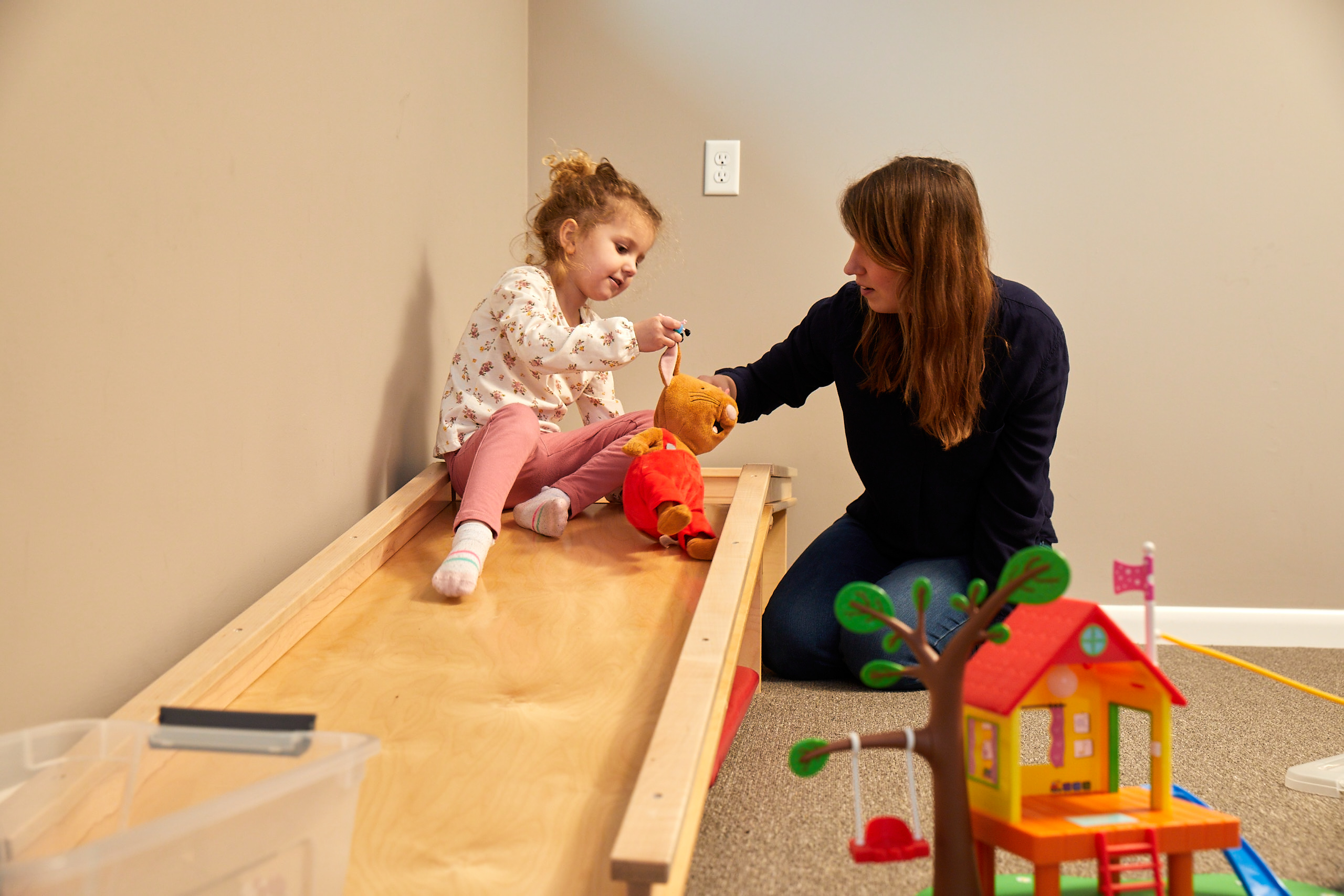 Speech therapist and child talking during play.